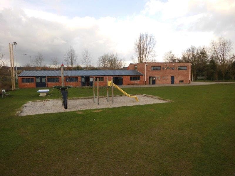 Chirolokalen met grasveld en speeltoestellen